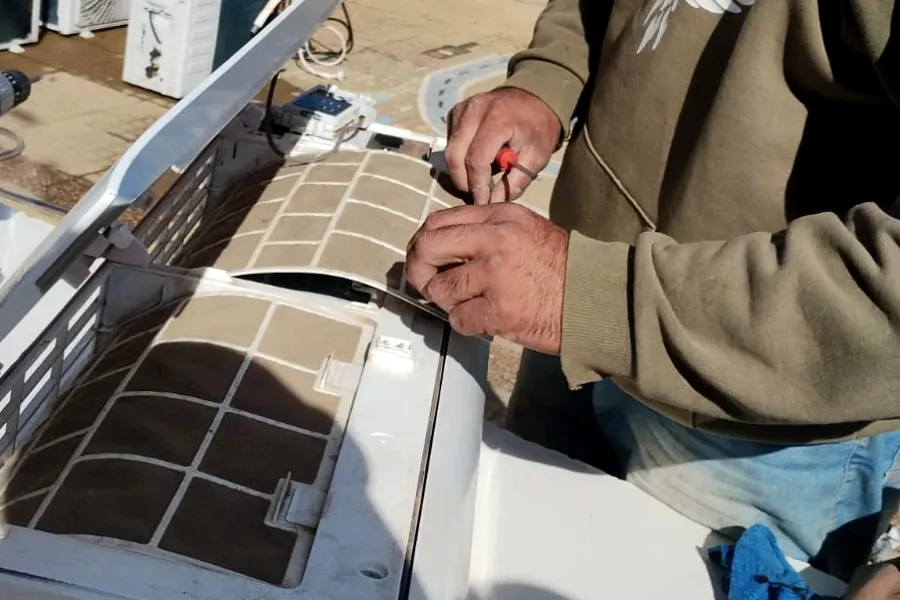 Trabajo real en obra: técnico haciendo el mantenimiento de una unidad interior, con los filtros a la vista.