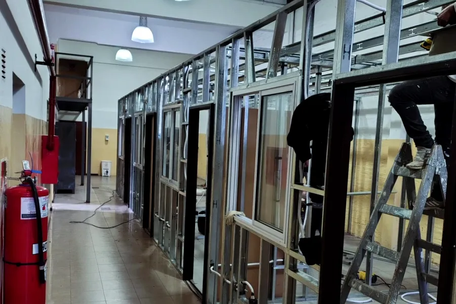 Trabajo real en obra: tabiques de perfiles metálicos armados a lo largo de un pasillo.