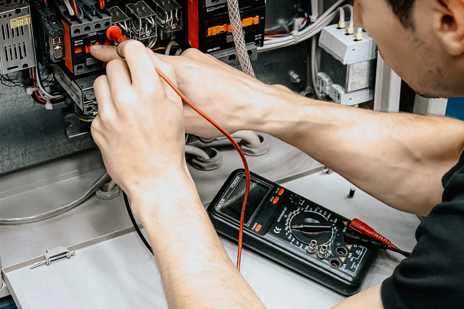 Imagen ilustrativa: electricista midiendo un tablero con un tester.