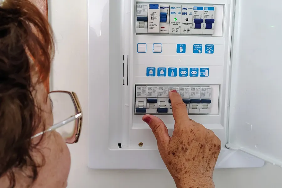 Imagen ilustrativa: mujer revisando las térmicas del tablero de una casa.