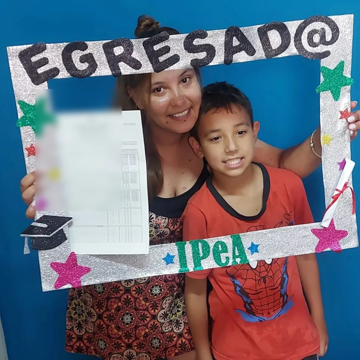 Egresada de IPEA celebrando con su hijo, con su certificado.